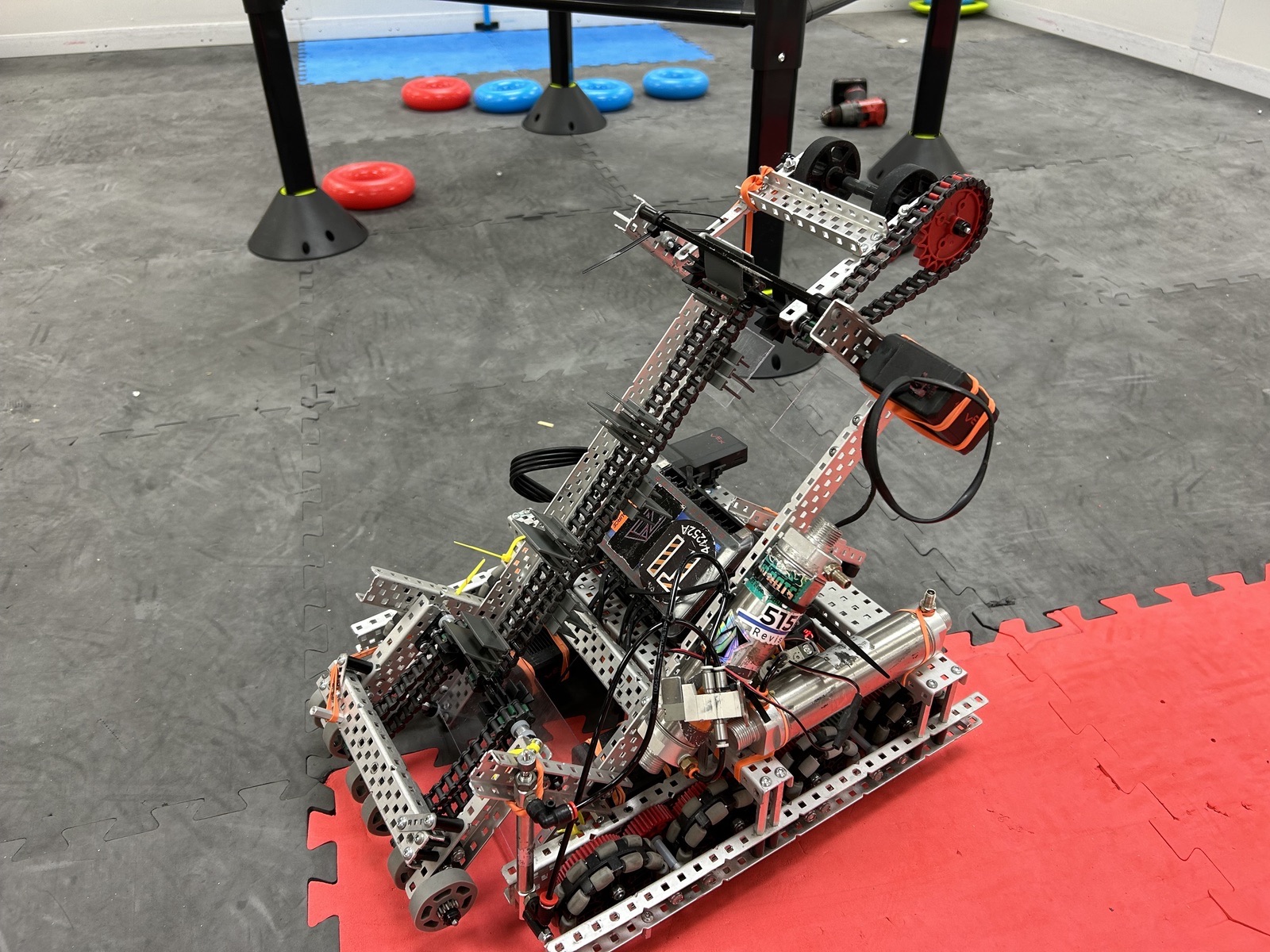 VEX competition robot with a chain driven lift arm and claw on the practice field